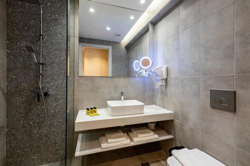 a bathroom with a sink and a shower at White Olive Premium Lindos in Pefki Rhodes