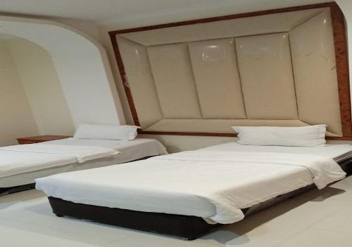 two beds in a room with white sheets and pillows at فندق سما اشبيليه الرياض in Riyadh