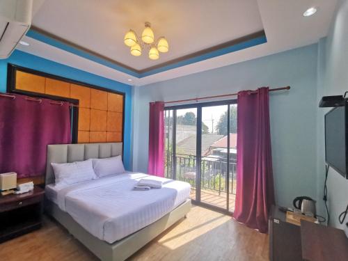 a bedroom with a bed and a sliding glass door at Kan Home Hotel in Kanchanaburi