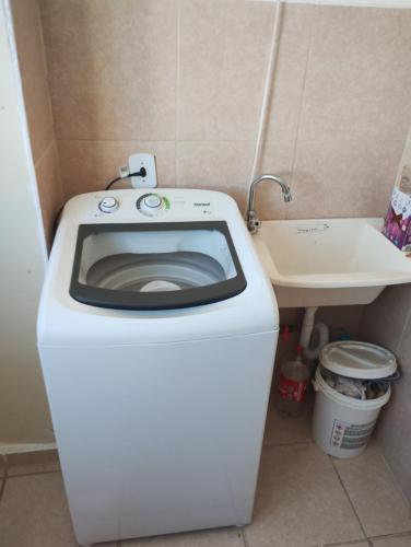 a white toilet in a bathroom with a sink at Apartamento Cabuçu in Nova Iguaçu