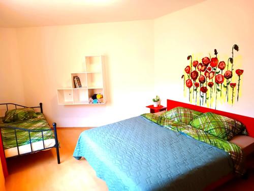 a bedroom with a bed with flowers on the wall at Hotel Zemlinski in Payerbach