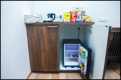 a small refrigerator under a counter in a kitchen at The Byke Suraj Club, Junagadh in Junagadh