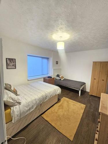 a bedroom with two beds and a large window at The perfect location when working in Swansea! in Swansea