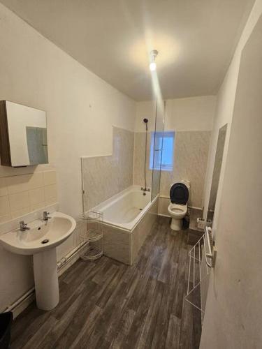 a bathroom with a sink and a tub and a toilet at The perfect location when working in Swansea! in Swansea