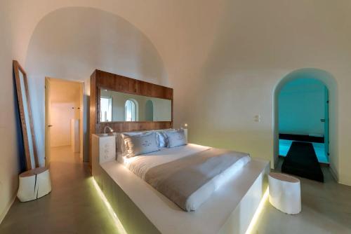 ein Schlafzimmer mit einem großen Bett und einem großen Spiegel in der Unterkunft Luxury Grand Santorini Villa - 3 Bedrooms - Unforgettable Caldera Sea Views and Outdoor Hot Tub - Fira in Fira