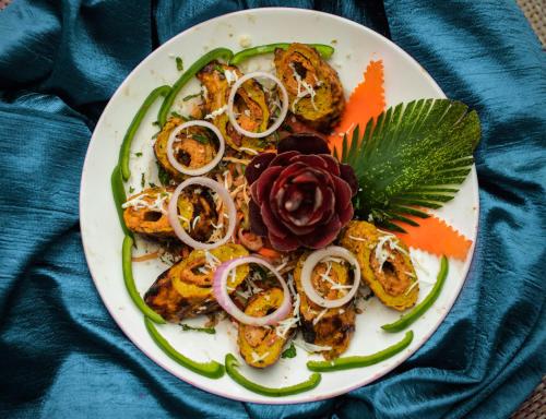 une assiette de nourriture avec des oignons et une fleur sur elle dans l'établissement BR Resort & Club, à Bhonrāsa