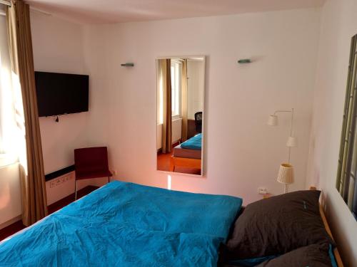 ein Schlafzimmer mit einem blauen Bett und einem Spiegel in der Unterkunft BMS BALANCE - Gemütliche 4 Sterne Möblierung neben dem Parkhotel in Wolfsburg