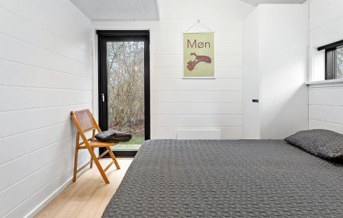 a bedroom with a bed and a chair at Awesome Home In Stege With Kitchen in Stege