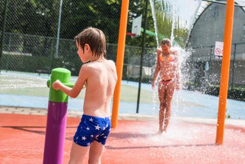 a young boy playing in a water park at Camping Het Veen in Brecht