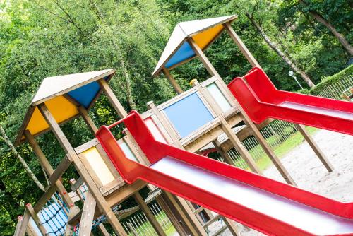 a set of three play equipment with red and orange chairs at Camping Het Veen in Brecht