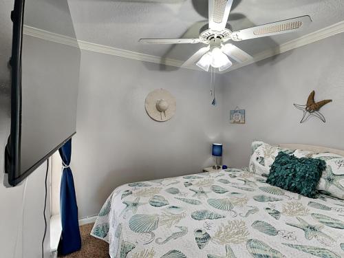 a bedroom with a bed with a ceiling fan at Victorian 5302- Oceans Away in Galveston