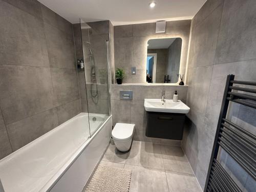 a bathroom with a toilet and a sink and a shower at Luxury York Minster Penthouse - Free Gym & Parking in York