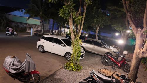 a group of cars parked next to trees and motorcycles at กัญญ่า เพลส KANYA in Maha Sarakham