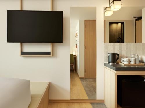 a kitchen with a television hanging on the wall at ASAI Kyoto Shijo in Kyoto