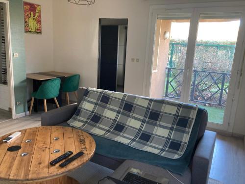 un salon avec un canapé et une table dans l'établissement Appt T2 Sept Deniers avec clim, à Toulouse