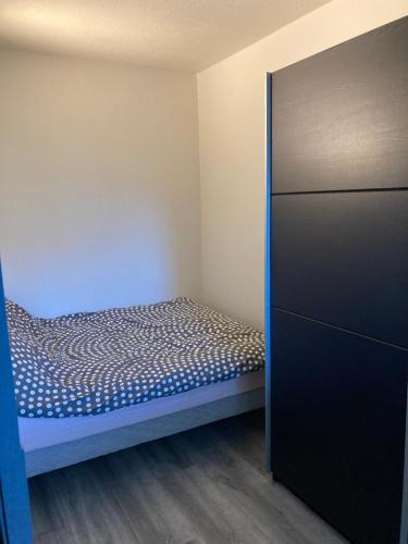 ein kleines Schlafzimmer mit einem Bett und einem Schrank in der Unterkunft Appt T2 Sept Deniers avec clim in Toulouse