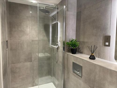 a shower with a glass door in a bathroom at Luxury York Minster Penthouse - Free Gym & Parking in York