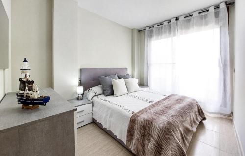 een witte slaapkamer met een groot bed en een raam bij House Panoramica Golf Holidays in Sant Jordi
