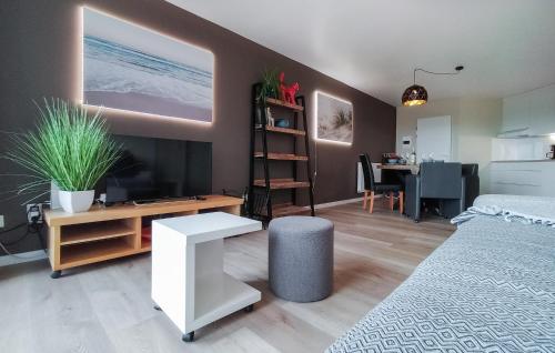 オーステンデにあるCozy Apartment In Oostende With Wifiのベッド、テレビ、テーブルのある寝室