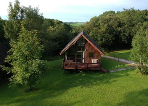 a small cabin in the middle of a green field at Eastcott Lodges in North Tamerton