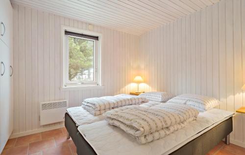 斯凱恩的住宿－Beautiful Home In Skjern With Kitchen，一间卧室配有三张床和枕头。