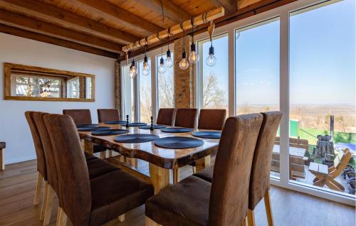 a dining room with a wooden table and chairs at Awesome Home In Aljmas in Aljmaš