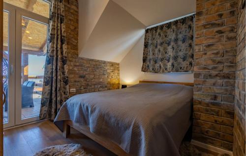 a bedroom with a bed and a brick wall at Awesome Home In Aljmas in Aljmaš