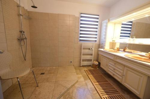 y baño con ducha y lavamanos. en Very pleasant vacation rental with heated pool in the Luberon, en Gargas