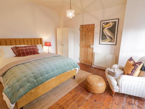 a bedroom with a large bed and a chair at The Old Rectory Coach House in Rathmullan