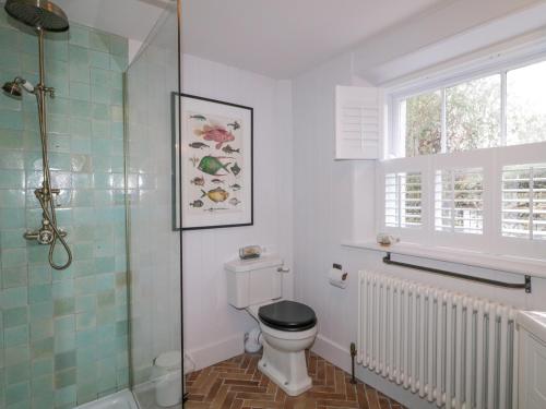 a bathroom with a toilet and a glass shower at The Old Rectory Coach House in Rathmullan
