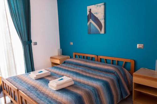 a bedroom with a bed with two towels on it at B&B Scarabeo Milazzo in Milazzo