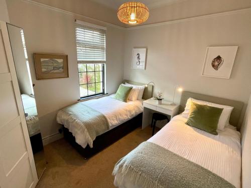 a bedroom with two beds and a window at The Cottage Central Newcastle in Newcastle