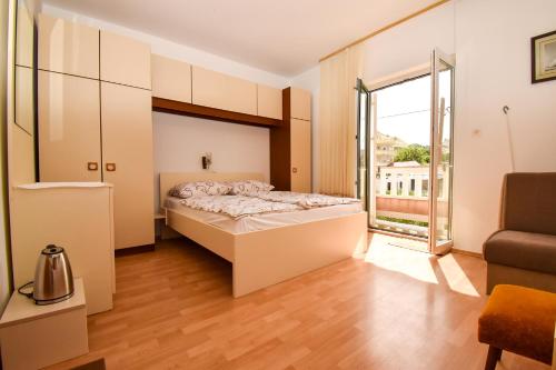 a bedroom with a bed and a large window at Rooms Anđela in Rab