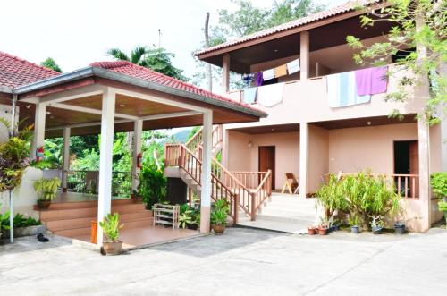 a house with a staircase and a porch at Heimat Garden in Ban Lo Pa Ret