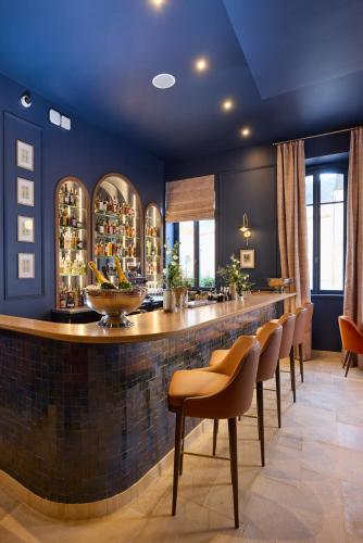 a bar with a row of chairs in a room at Maison 1896 in Beaune