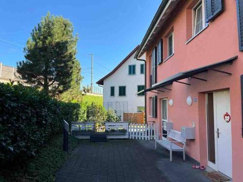 a pink house with a bench in front of it at Gemütliches Haus in Knonau in Knonau