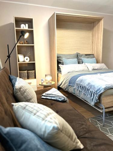 a bedroom with a large bed and a couch at Zentrale Lage - Ideal für Arbeit & Erholung in Graben-Neudorf