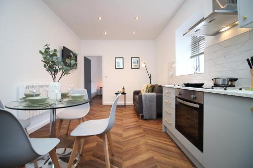 a kitchen and living room with a table and chairs at 101 Walter Road in Swansea