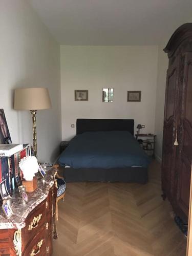 - une chambre avec un lit, une table et une commode dans l'établissement Appartement 4 personnes avec Jardin-Paris centre, à Paris