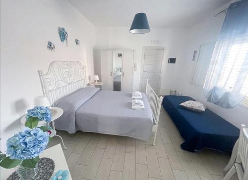 - une chambre avec un lit et une table ornée de fleurs bleues dans l'établissement Borgata Mazzarelli 2, à Marina di Ragusa