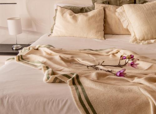 a bed with a blanket and flowers on it at Bairos House - Coastal Escape in Ribeira Brava