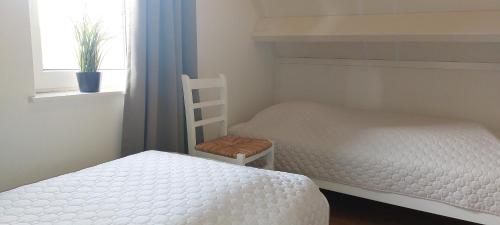 a bedroom with two bunk beds and a chair at Vakantiewoning de Boshoorn in Serooskerke