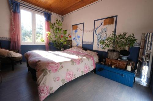 een slaapkamer met een bed met roze bloemen erop bij jolie location, maison avec piscine et joli jardin fleuri, à oppède dans le luberon en provence – 6 personnes in Oppède