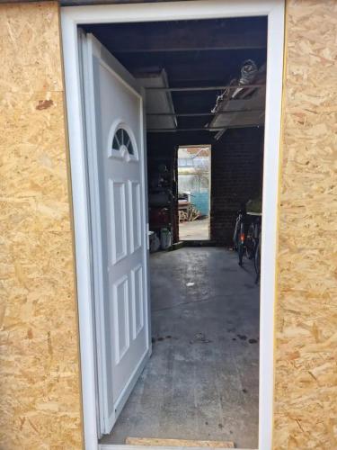 une porte ouverte menant à un garage avec couloir dans l'établissement Tiny House La Cabane du Bohémien, à Saint-Quentin
