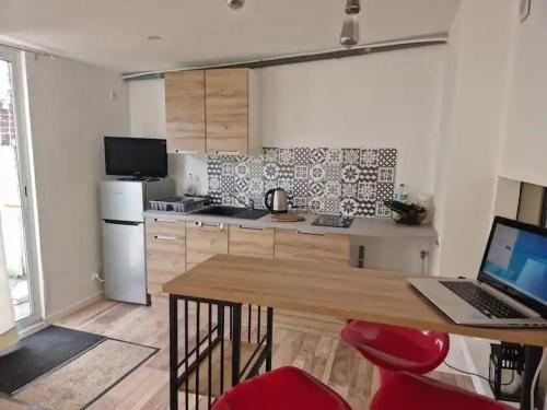 une cuisine avec un ordinateur portable sur une table dans l'établissement Tiny House La Cabane du Bohémien, à Saint-Quentin