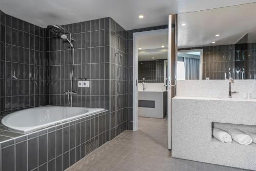 La salle de bains est pourvue d'une baignoire, d'une douche et d'un lavabo. dans l'établissement Quality Hotel The Mill, à Malmö