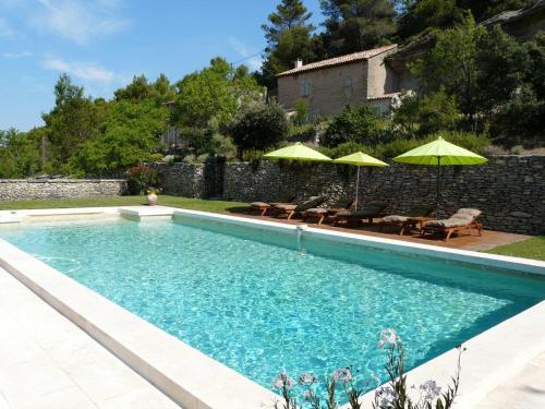 une piscine avec chaises et parasols dans une cour dans l'établissement 19th century Provencal Mas with pool in Provence in the Luberon, sleeps 6, à Lacoste