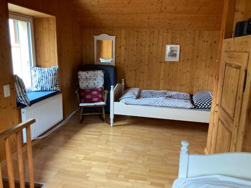 een kleine kamer met 2 bedden en een stoel bij Appartamento Evelina in Airolo
