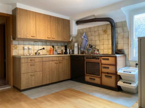 a kitchen with wooden cabinets and a sink at Appartamento Evelina in Airolo