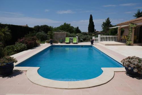 una piscina de agua azul en un patio en pleasant villa located in aureille, close to the center by foot, in the alpilles park, sleeps 6. en Aureille